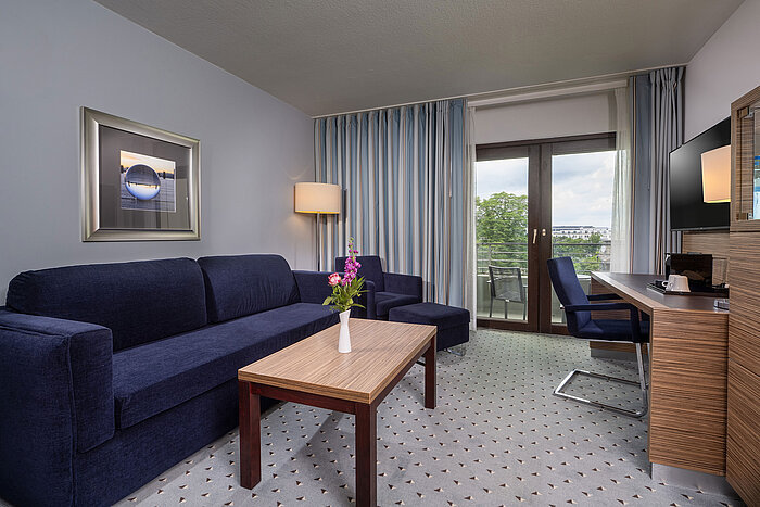 Bright living area of the Studio at the Maritim Hotel Darmstadt with a comfy sofa and balcony access