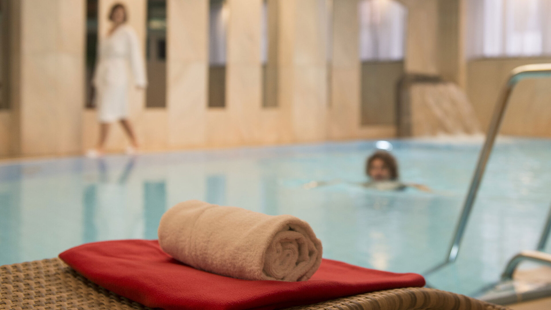 Towel by the pool in the wellness area of Maritim Hotel Stuttgart, guests enjoying a swim