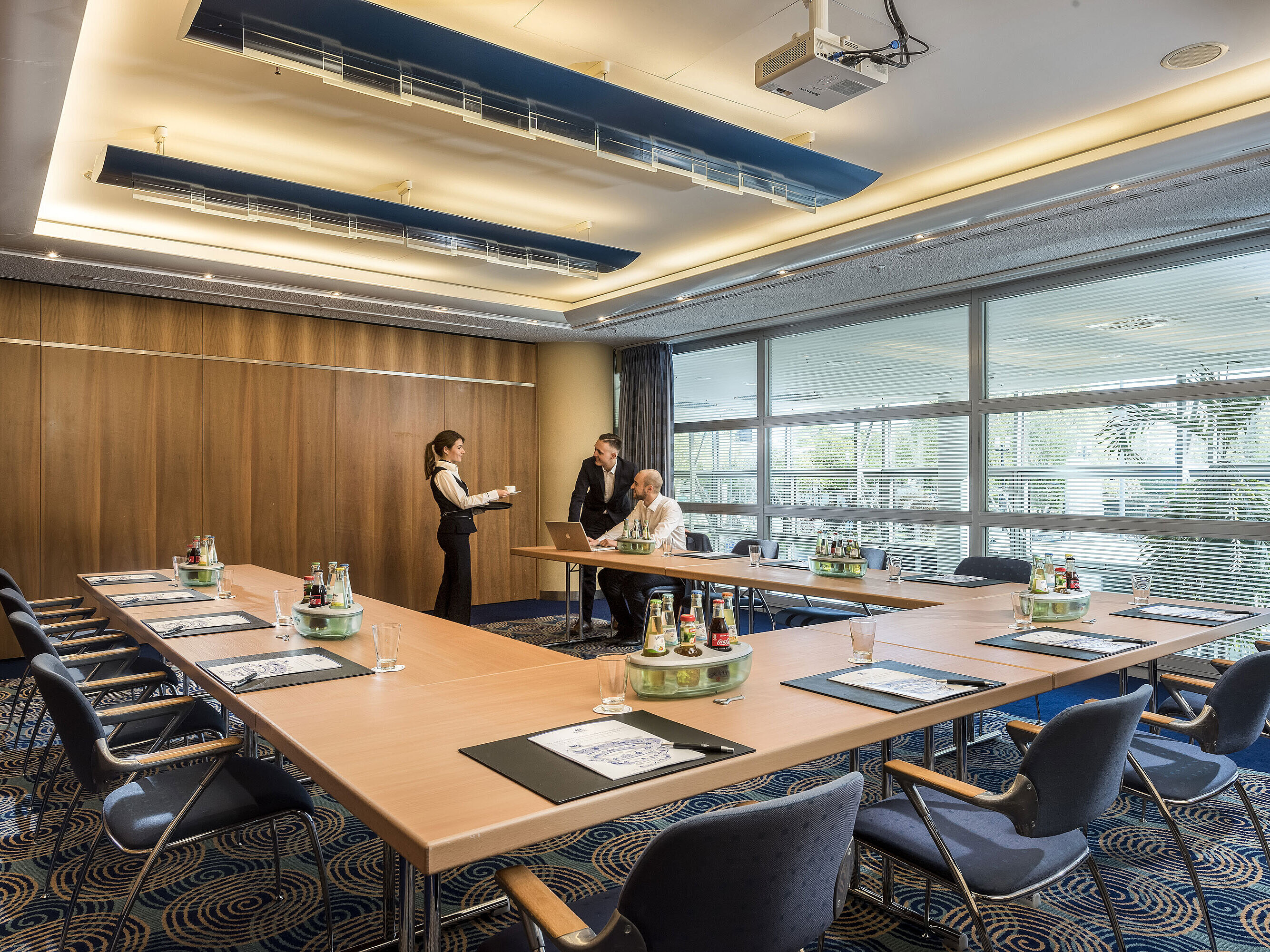 Meeting in a small conference room at Maritim Hotel Frankfurt with U-shaped seating, natural light, and staff service.