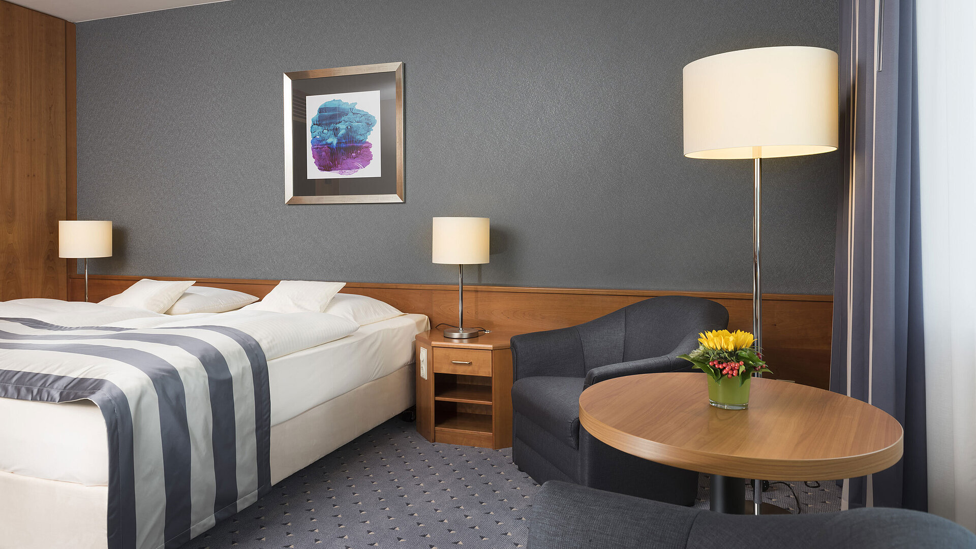 Comfortable hotel room at Maritim Hotel Ulm with double bed, seating area and modern design