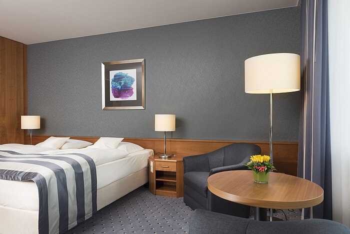 Comfortable hotel room at Maritim Hotel Ulm with double bed, seating area and modern design