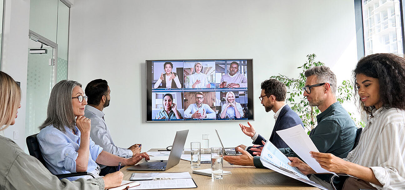 Business team in video conference with colleagues on large screen