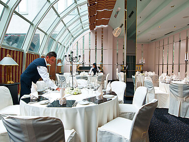 Event in the Wintergarten Elegantly set room for banquets and celebrations with glass roof at Maritim Hotel Munich