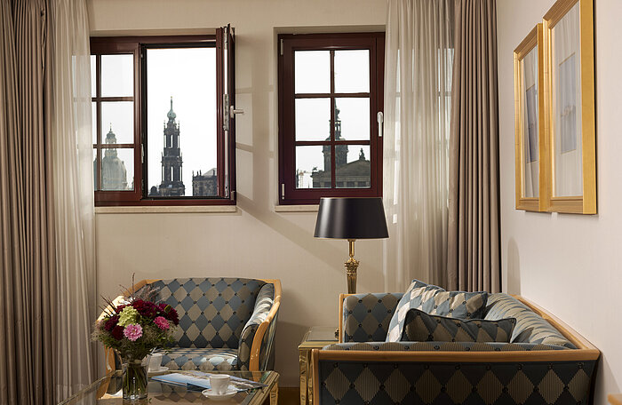 Room detail at Maritim Hotel Dresden with a view of the historic old town towers through two windows.