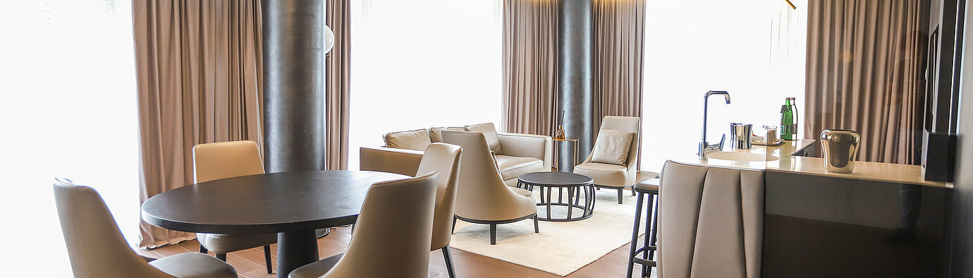 Modern suite with lounge area and dining table at the Maritim Hotel Plaza Tirana