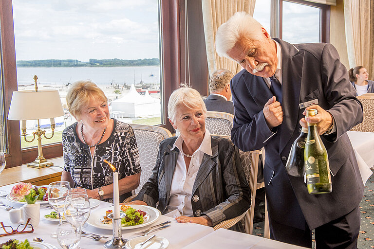 Waiter presents fine wines to guests in the restaurant of Maritim Hotel Travemünde.