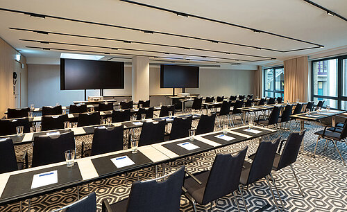 Meeting room 1 with classroom-style seating, conference tables, modern media technology and bright interior.