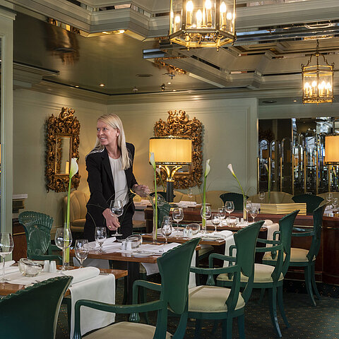 Restaurant "La Galerie" at Maritim Hotel Cologne with set tables and an employee preparing the restaurant.