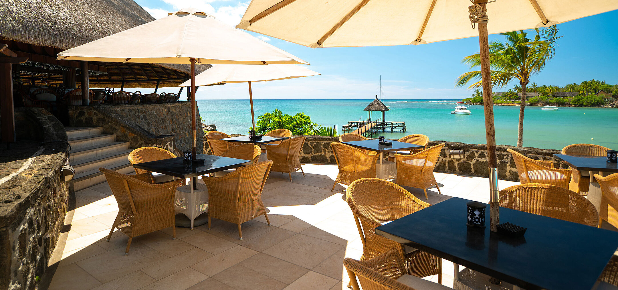 Beach restaurant with sun umbrellas, sea view and jetty for relaxed dining at Maritim Resort