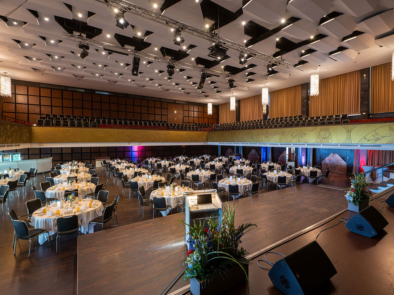 "Saal Maritim" with festively set tables, stage and seating for an event