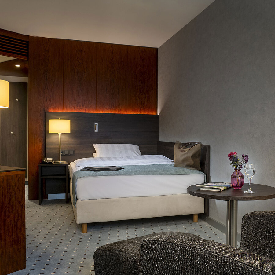 Modern single room with stylish furnishings, cozy lighting and comfortable seating at the Maritim Hotel Bremen.
