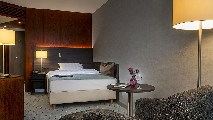 Modern single room with stylish furnishings, cozy lighting and comfortable seating at the Maritim Hotel Bremen.