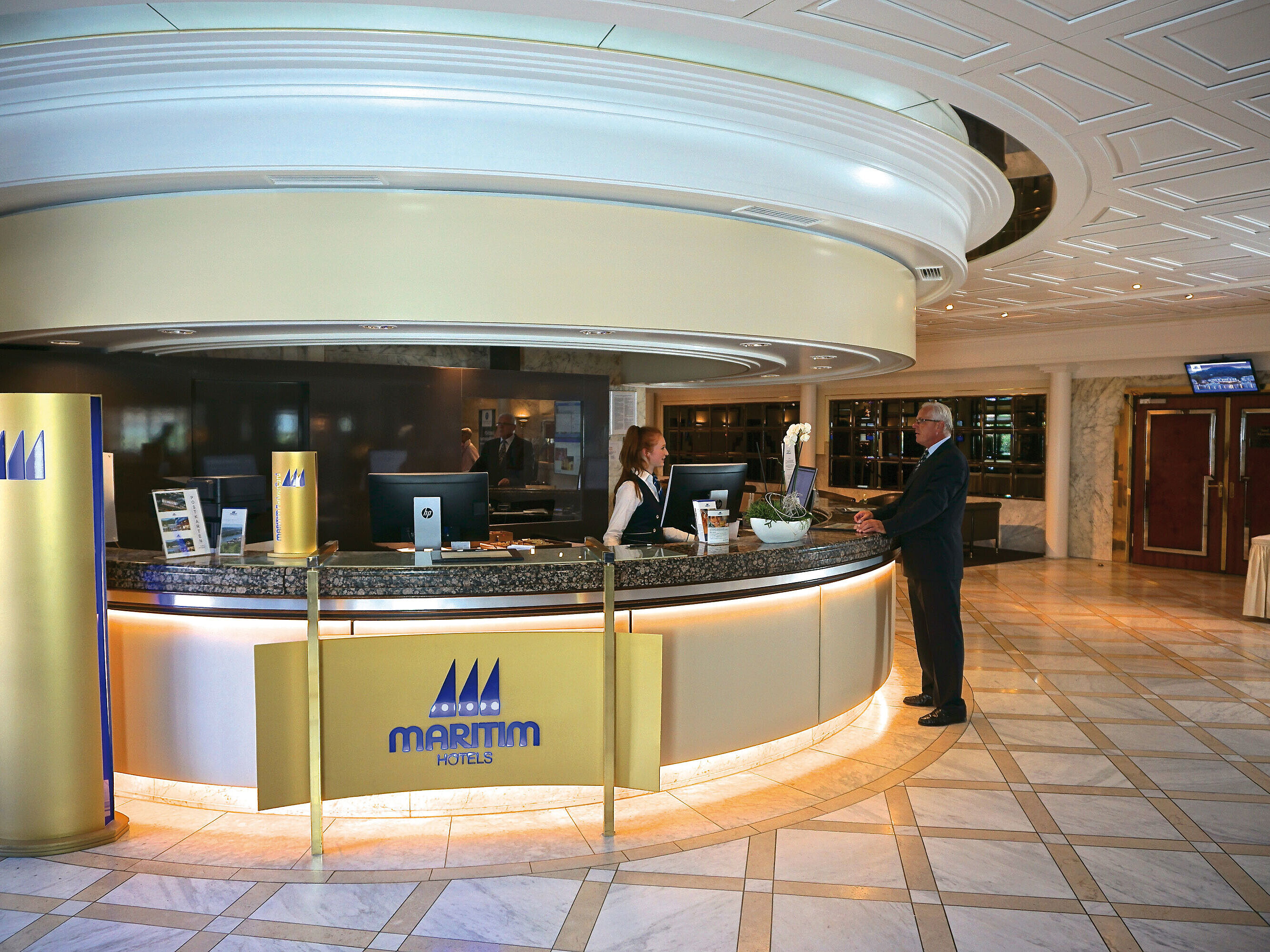 Friendly welcome at the reception of the Maritim Hotel Königswinter with stylish interior.