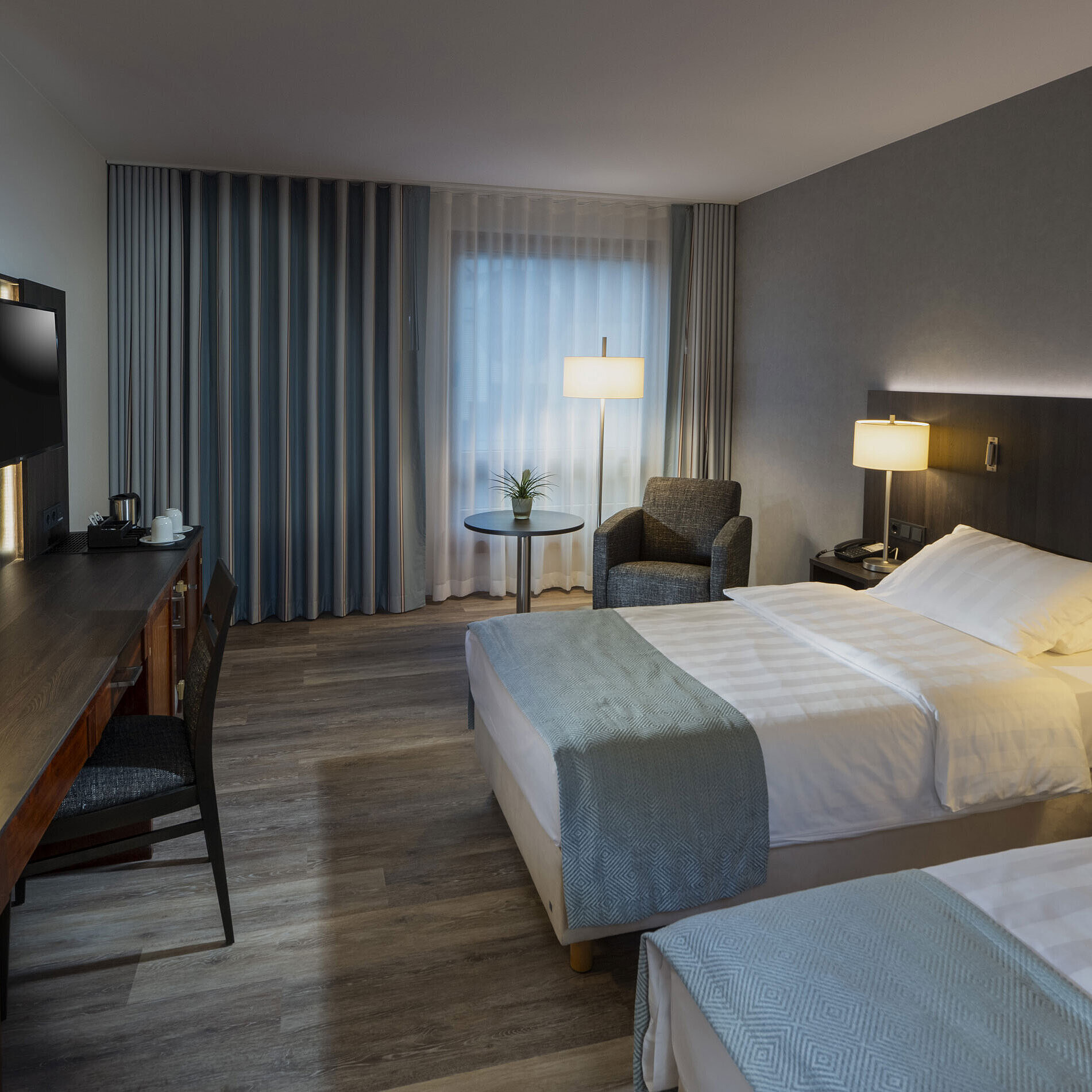 Comfortable twin room at Maritim Hotel Bremen with two single beds, cozy sitting area, and modern ambiance.