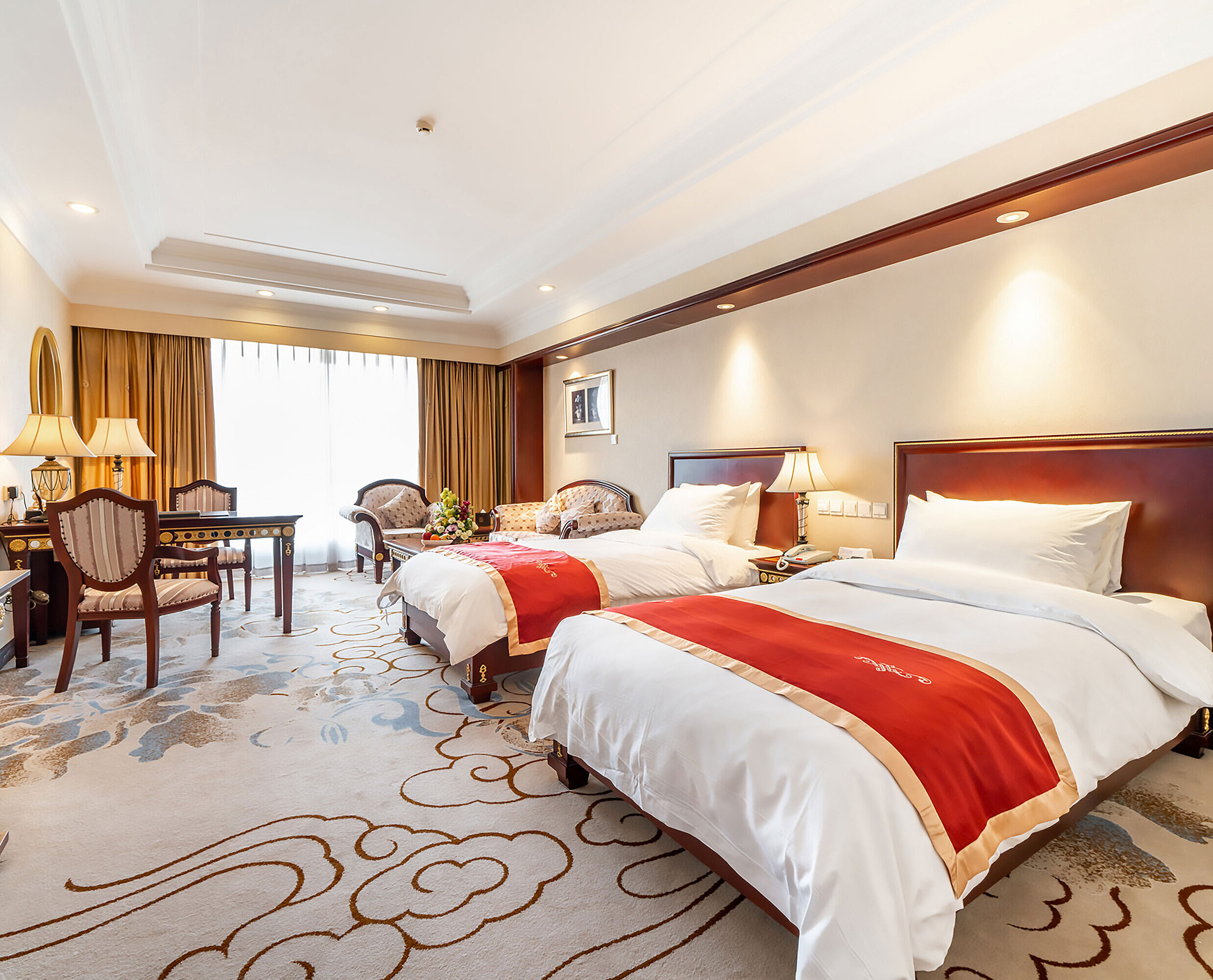 寬敞的經典酒店客房，配備兩張單人床、休憩區、書桌及帶自然採光的大窗戶