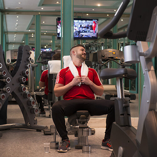 Guest working out in the gym at Maritim Hotel Stuttgart with dumbbells and machines