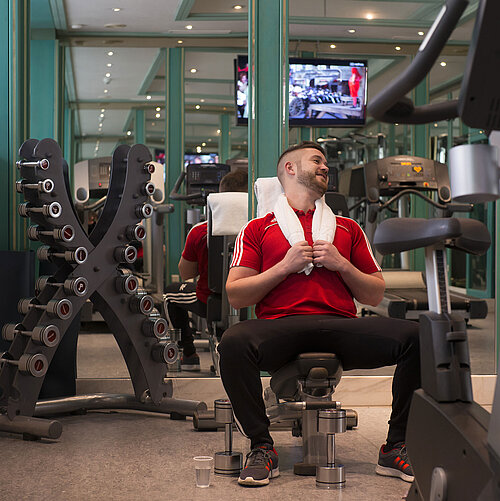 Guest working out in the gym at Maritim Hotel Stuttgart with dumbbells and machines