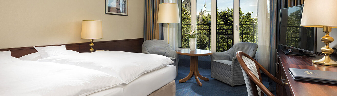 Superior double room at Maritim Hotel Cologne with cozy decor and view of the Cologne Cathedral.