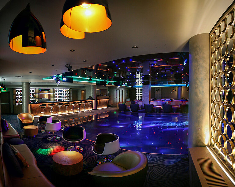 Hotel bar and club area with dance floor, modern lighting and stylish seating