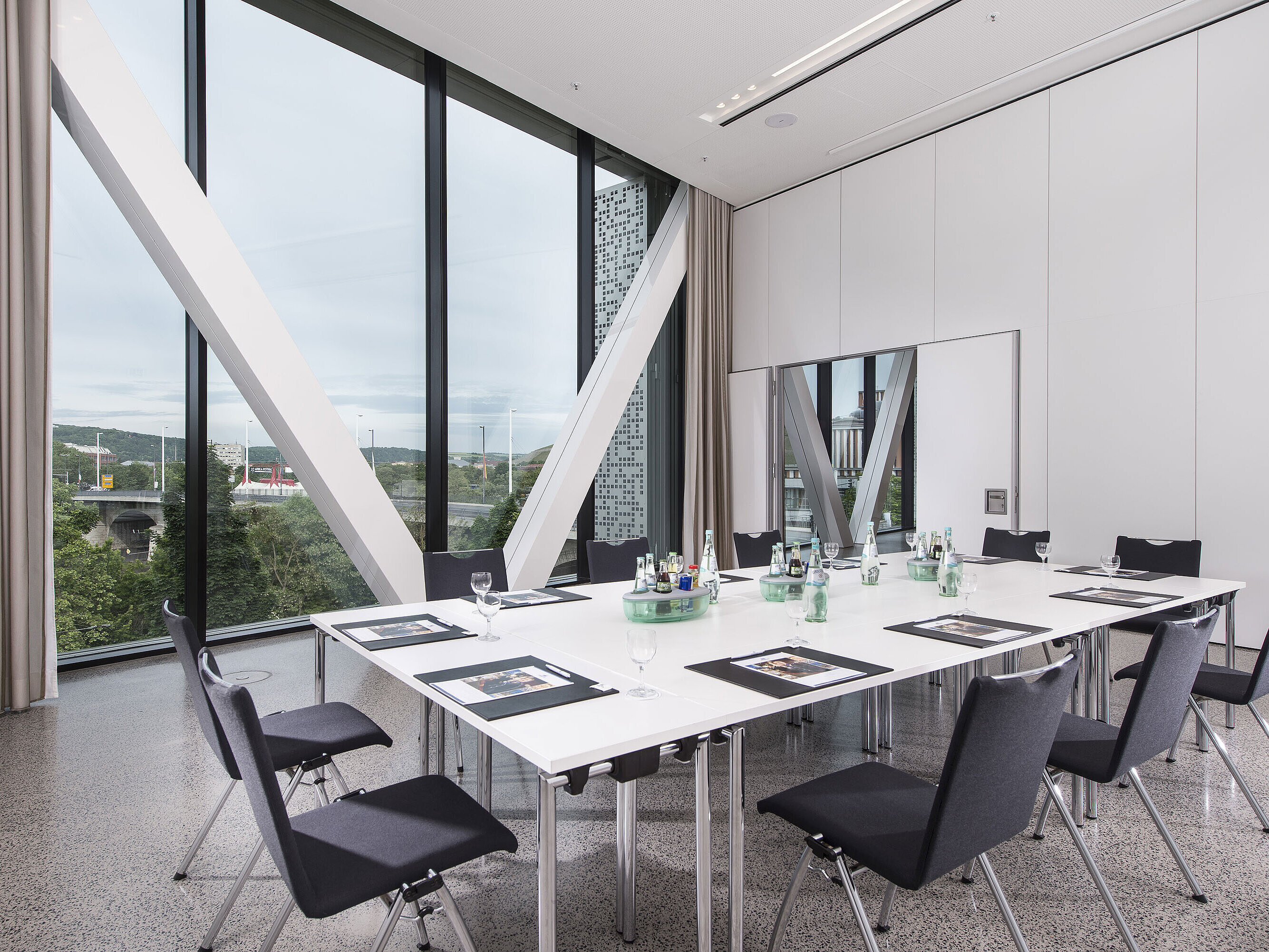 Bright meeting room at Maritim Hotel Würzburg with large window and view of the Alte Main Bridge