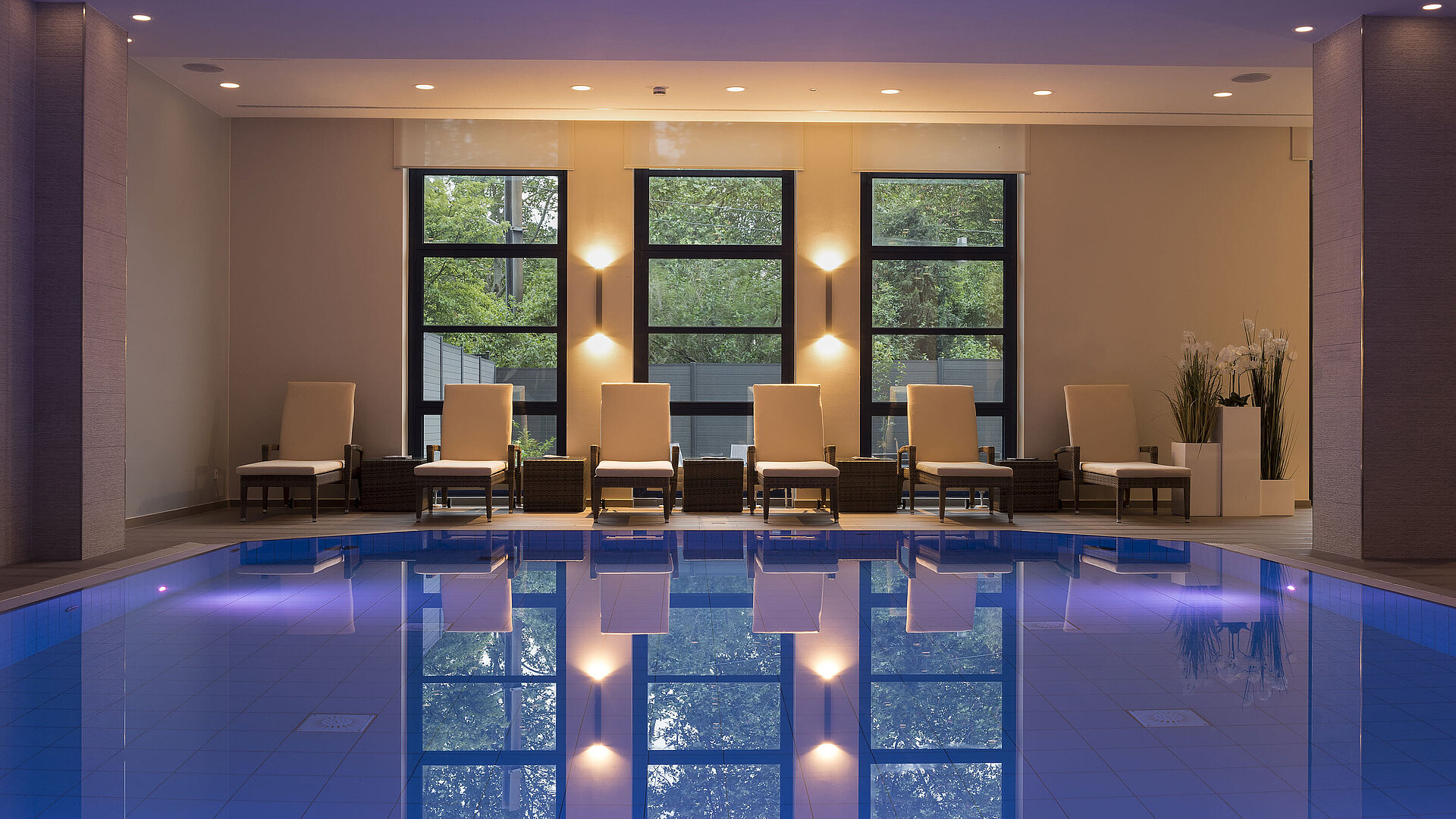 Pool area at Maritim Hotel Bonn with stylish loungers and calming lighting for ultimate relaxation.