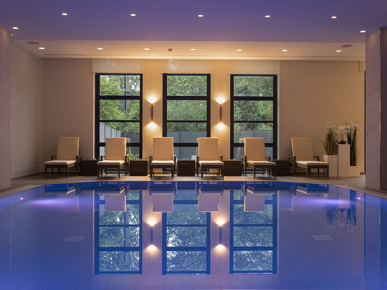 Pool area at Maritim Hotel Bonn with stylish loungers and calming lighting for ultimate relaxation.