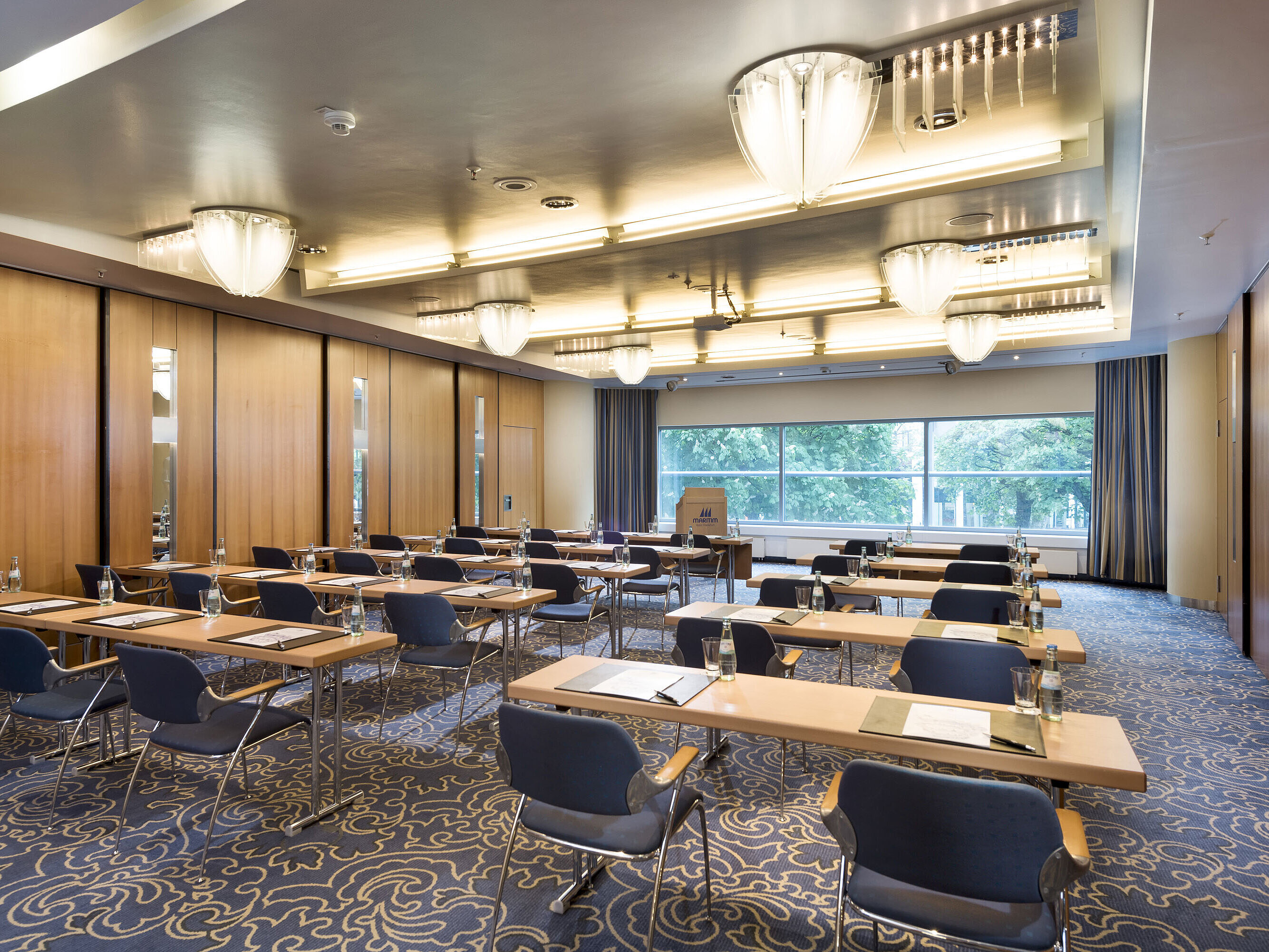 Bright conference room at Maritim Hotel Frankfurt with row seating, modern facilities, and large windows overlooking greenery