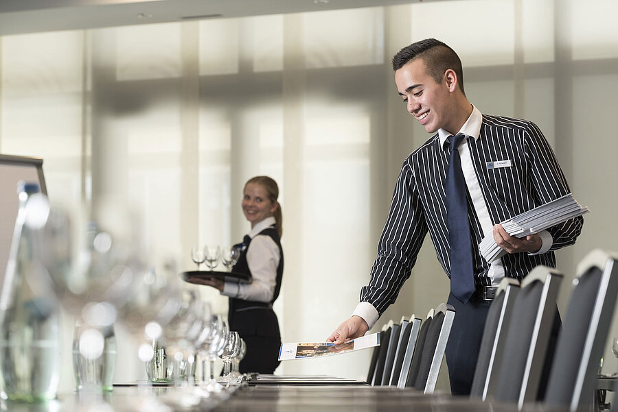 Friendly service team at Maritim Hotel Bad Homburg preparing conference room.