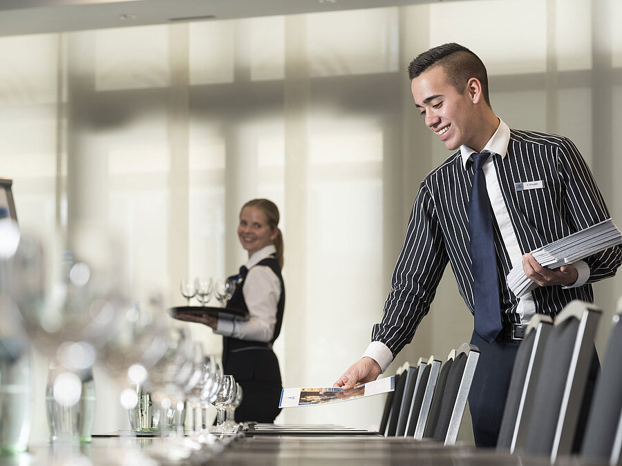Friendly service team at Maritim Hotel Bad Homburg preparing conference room.