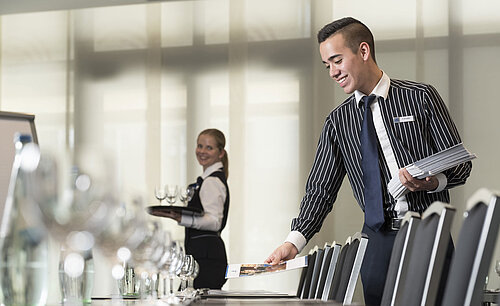 Friendly service team at Maritim Hotel Bad Homburg preparing conference room.