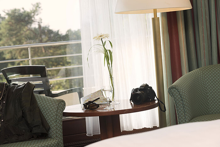 Table with camera, city map and glass at Maritim Hotel Bad Salzuflen near balcony
