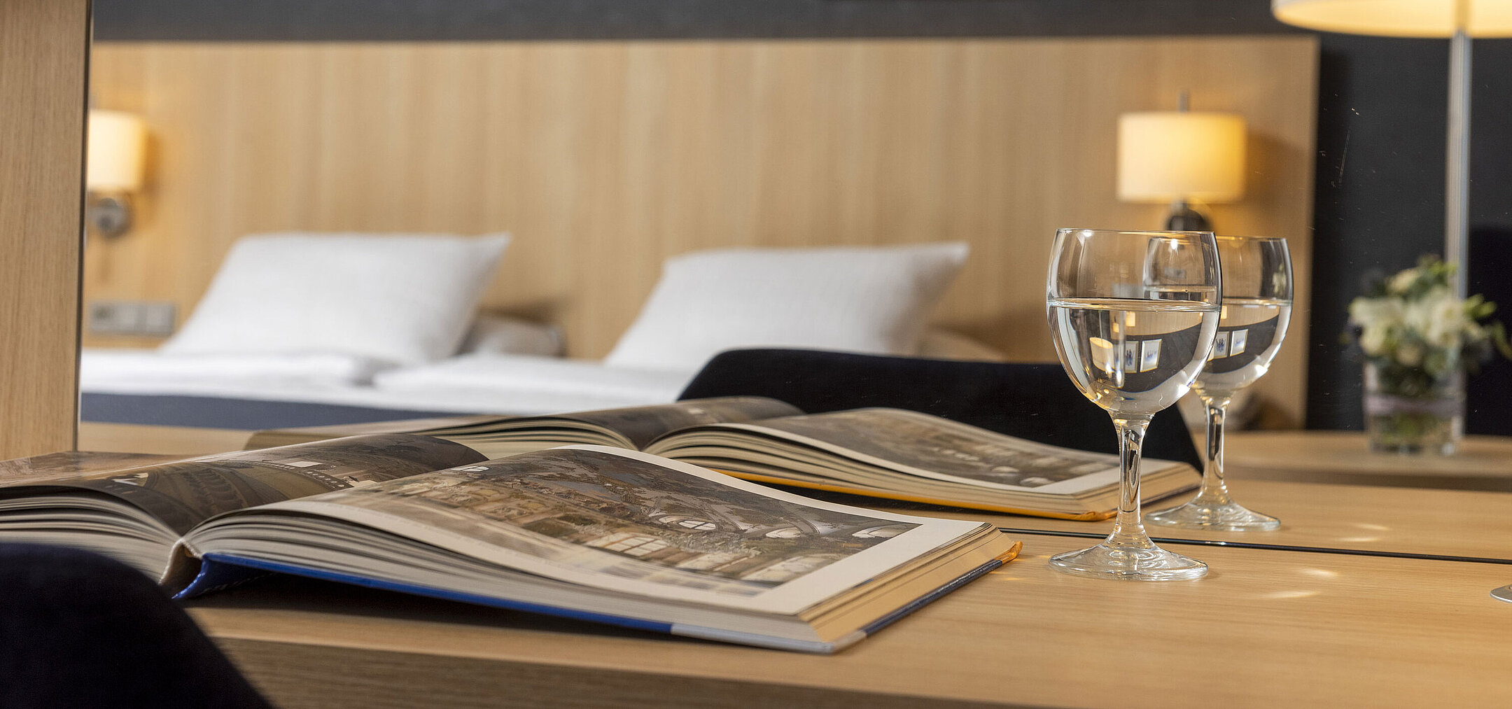 Cozy comfort room at Maritim Hotel Würzburg with mirror, open coffee-table book and water glasses