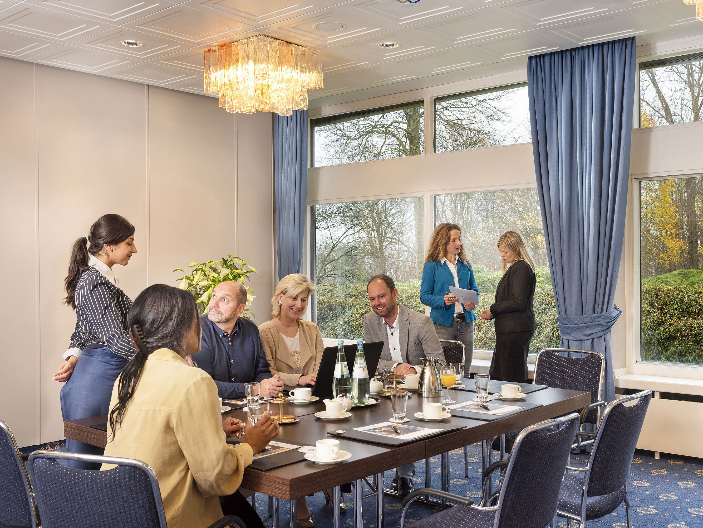 Salon Flensburg in the Maritim Hotel Kiel, a group of people at a meeting, friendly service and large windows.