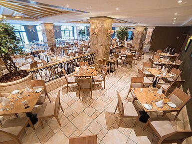 Elegant restaurant area with set tables, columns and bright interior design