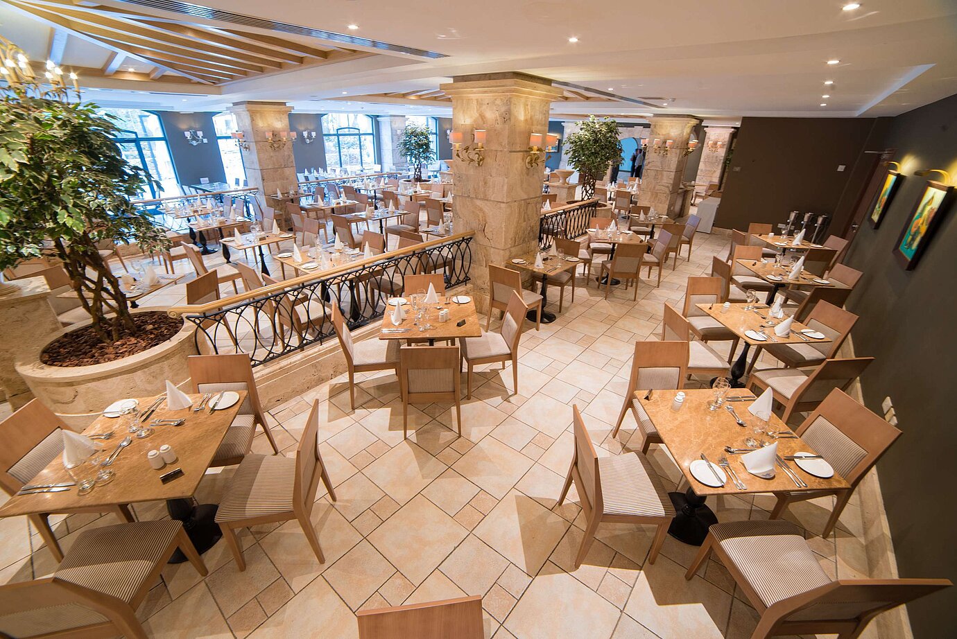 Elegant restaurant area with set tables, columns and bright interior design