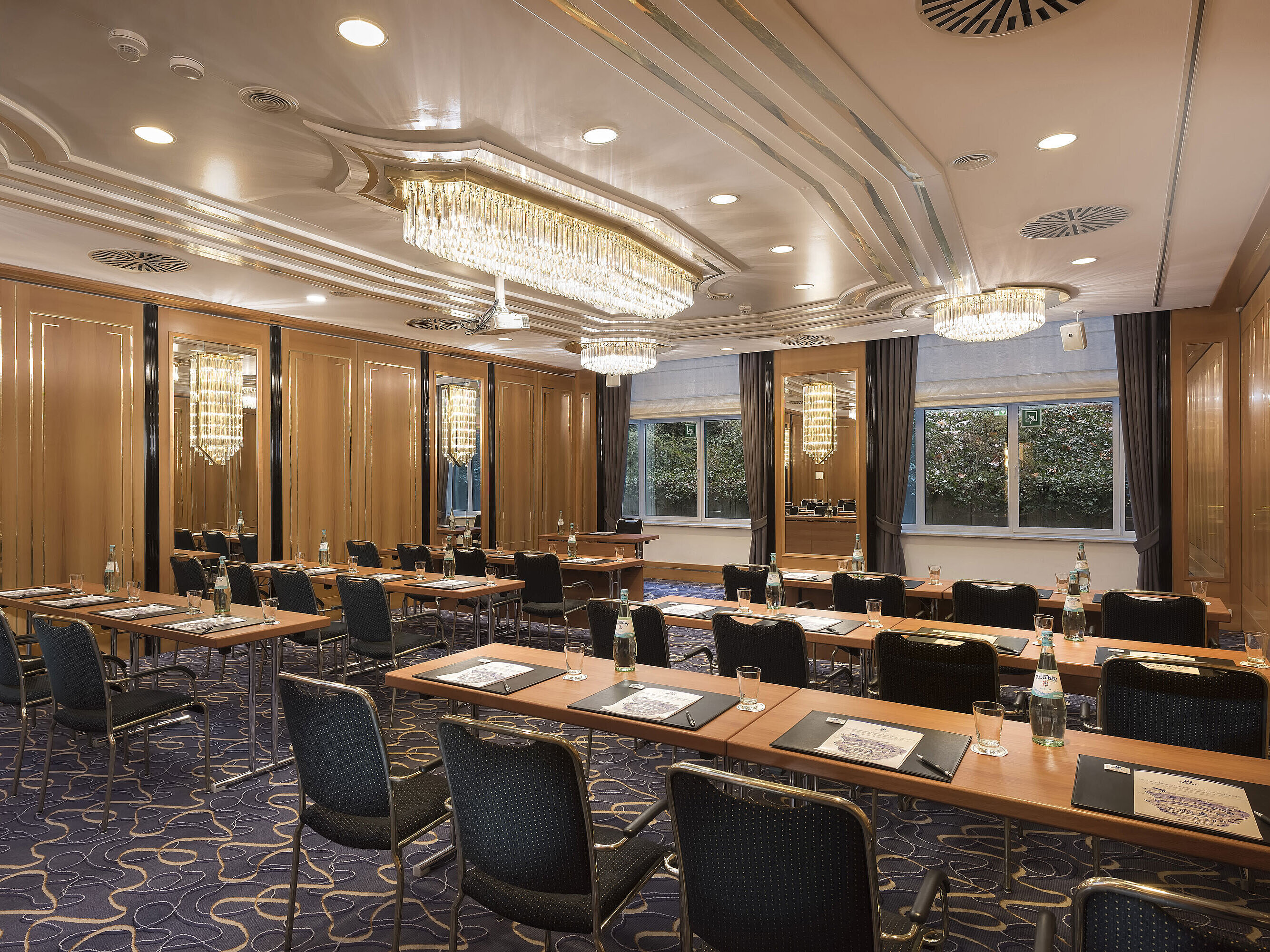 Conference room with row seating, natural light and chandeliers at Maritim Hotel Stuttgart