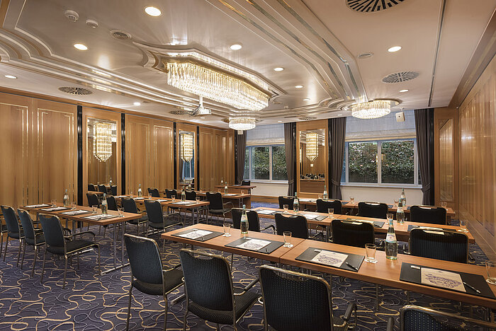 Conference room with row seating, natural light and chandeliers at Maritim Hotel Stuttgart