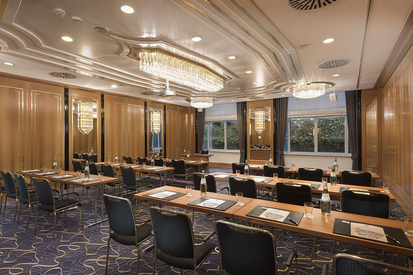 Conference room with row seating, natural light and chandeliers at Maritim Hotel Stuttgart