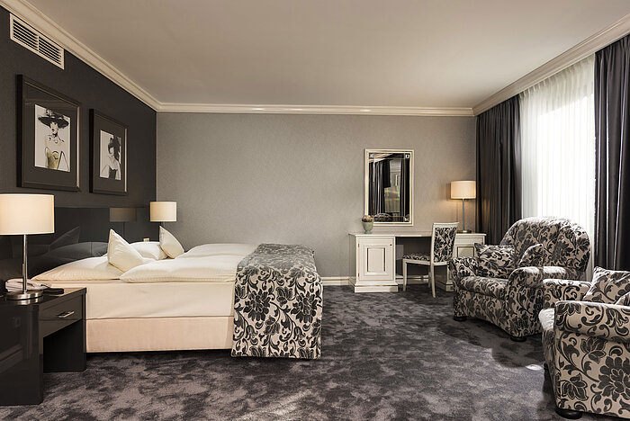 Spacious suite at Maritim Hotel Ulm with luxurious carpet, elegant seating and vanity