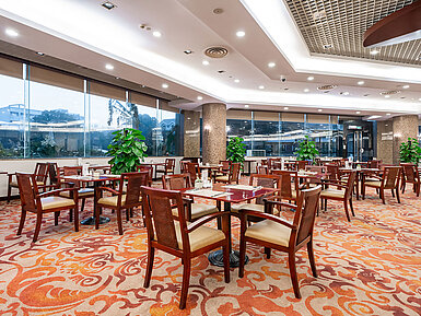 現代化餐廳配備大面積落地窗，搭配典雅木質餐桌與充沛自然光線，營造出輕鬆愜意的用餐體驗。