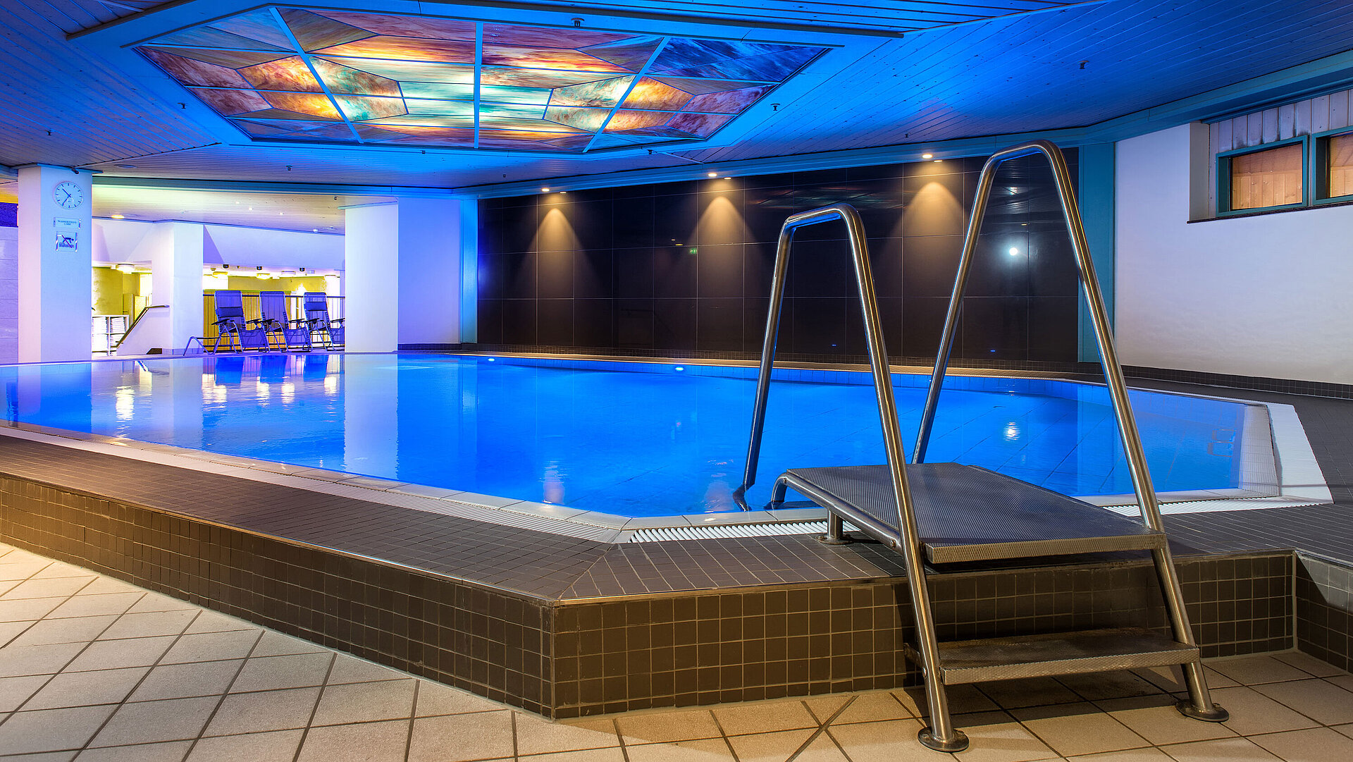 The illuminated indoor pool at Maritim Hotel, inviting relaxation and recreation.