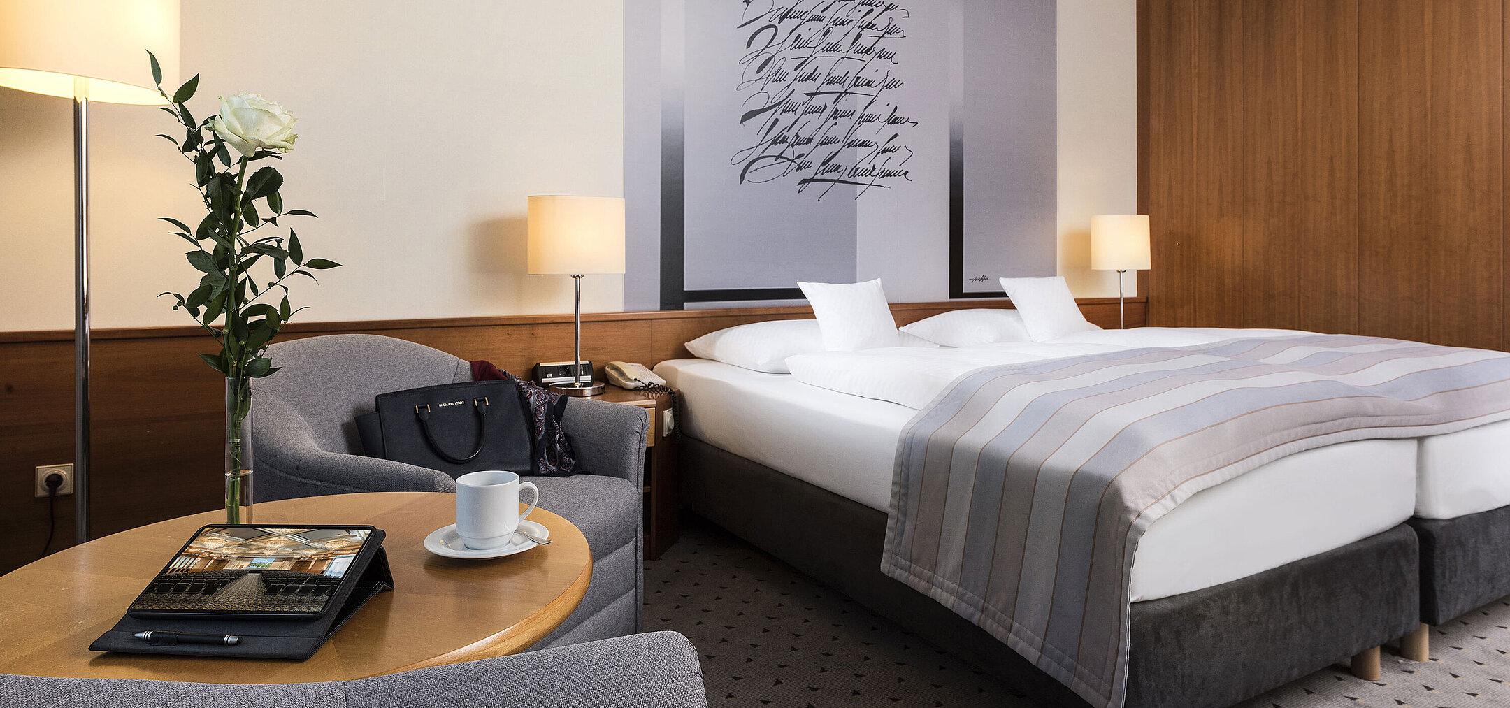 Elegant classic double room with stylish wall design, cozy double bed, and seating area at Maritim Hotel Hannover.