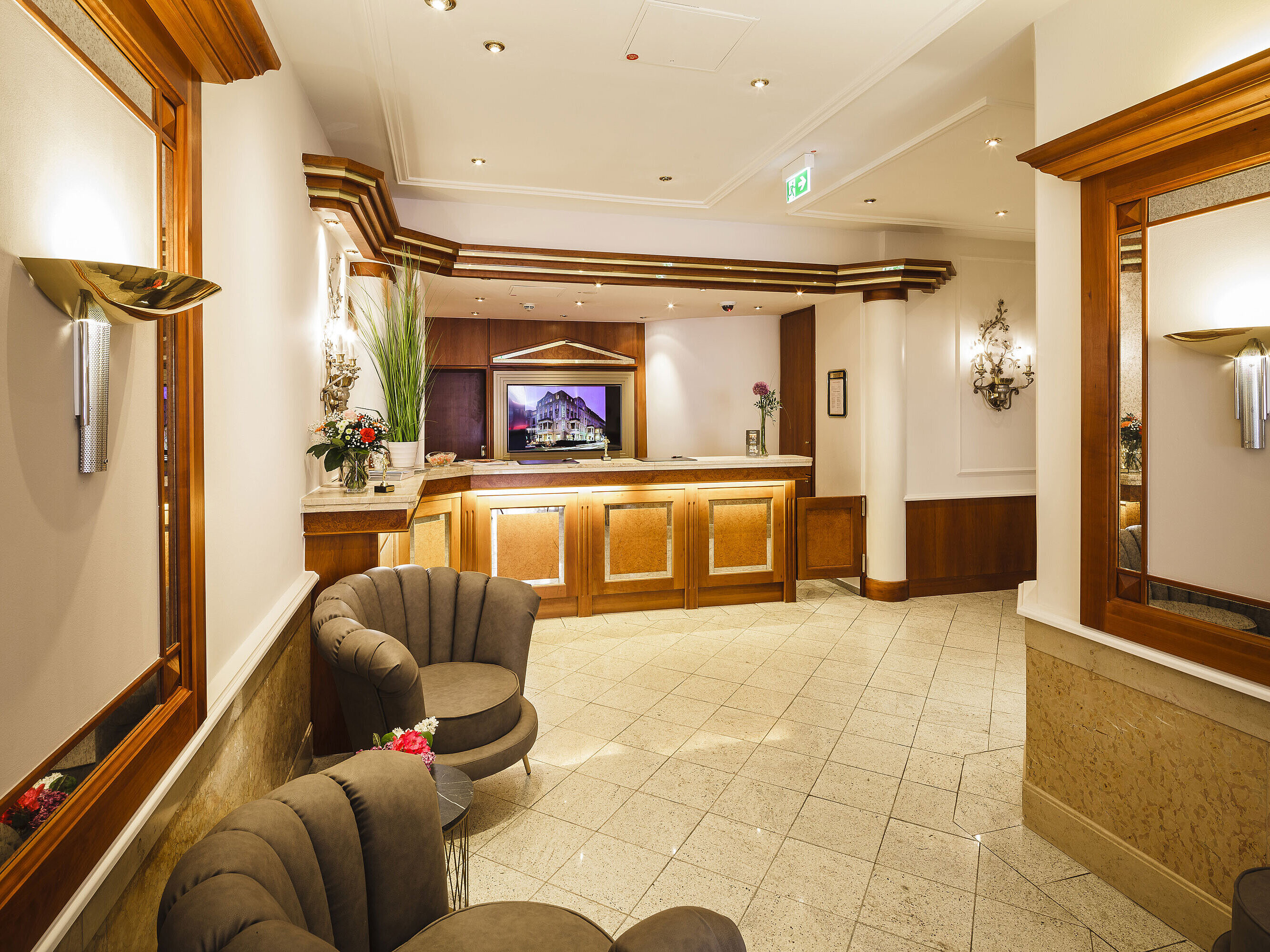 Elegant lobby with reception, seating area and warm wood details at Hansa Hotel Wiesbaden