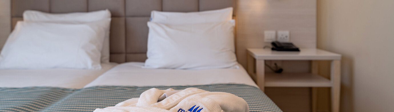 Close-up of a hotel bed with bathrobe and soft bedding