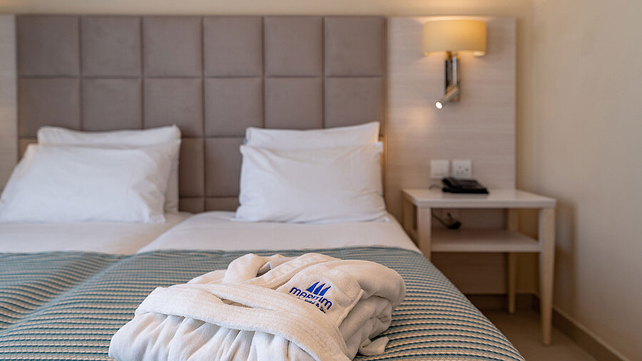 Close-up of a hotel bed with bathrobe and soft bedding