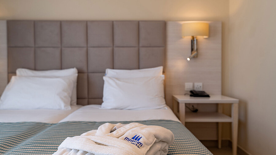 Close-up of a hotel bed with bathrobe and soft bedding