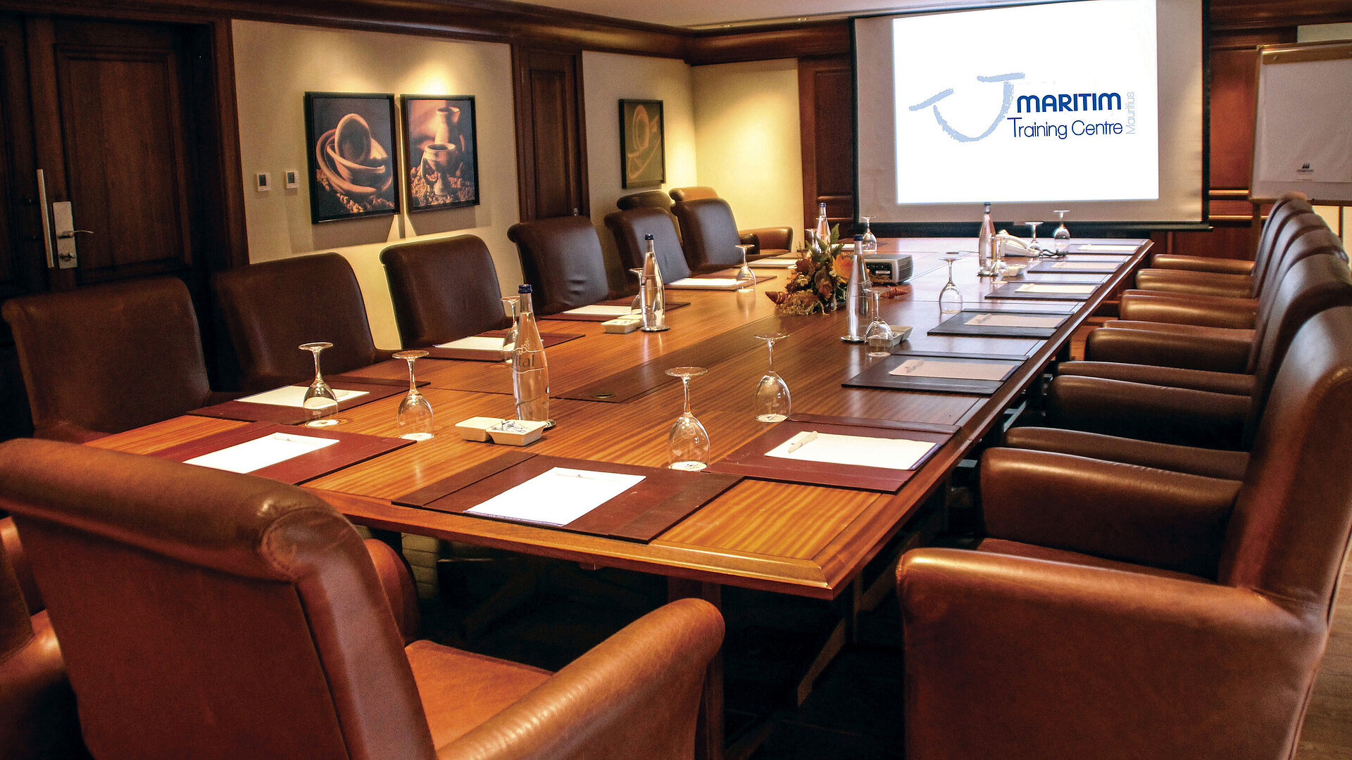 The meeting room at Maritim Hotel is well-equipped with a large conference table and a projector