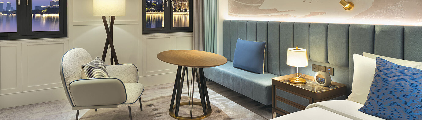 Modern hotel room with cosy seating area and skyline view at Maritim Hotel Taicang