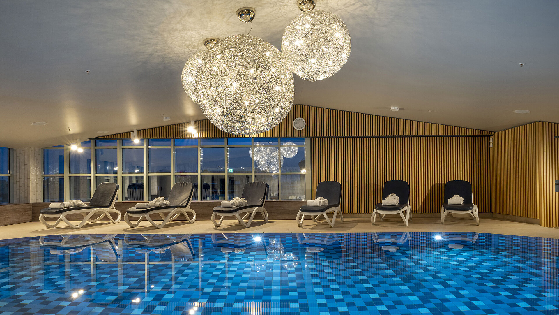 Blue-tiled pool and lounge chairs at the Maritim Hotel Munich