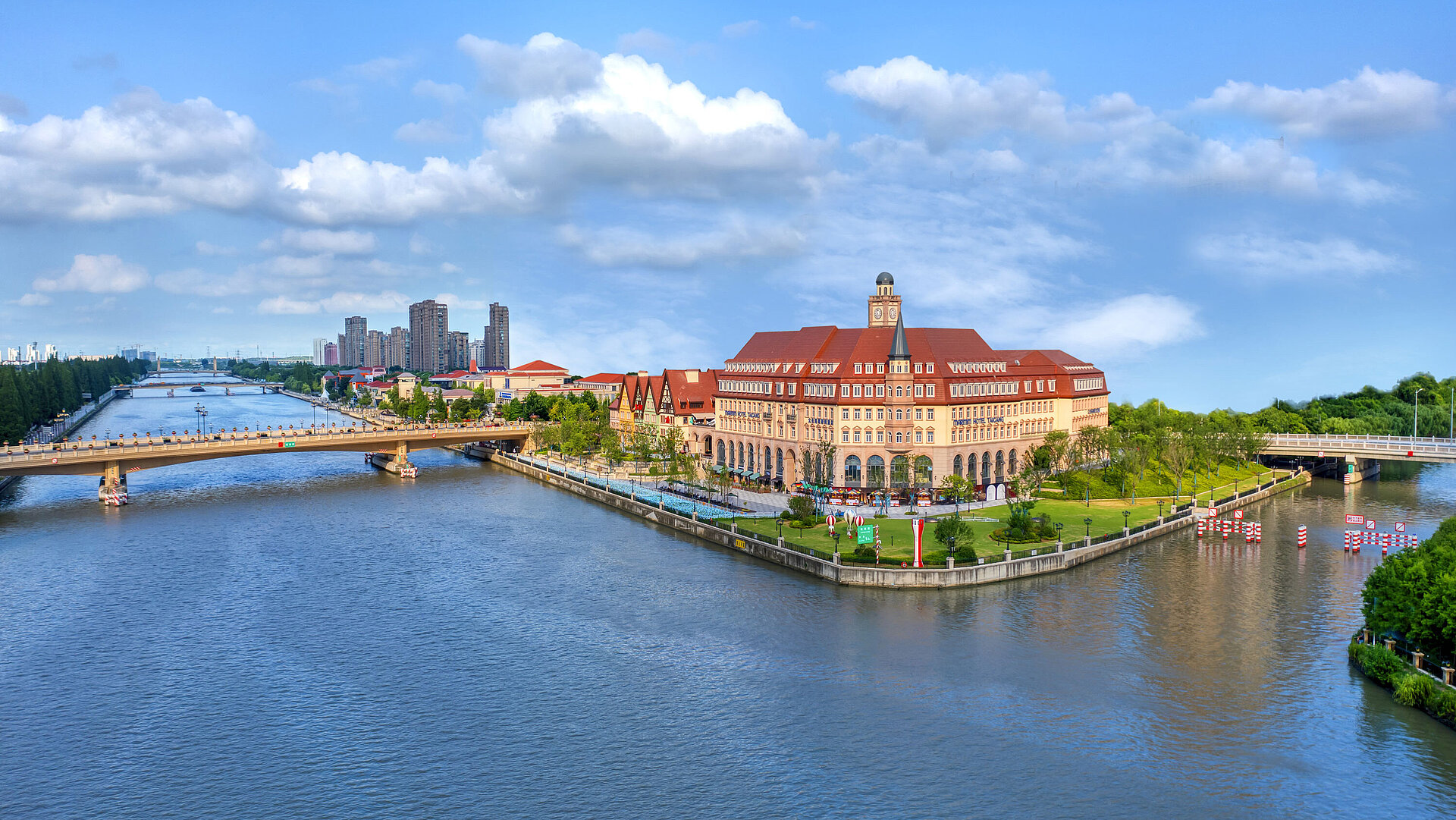 Aerial view of Maritim Hotel Taicang on a riverside peninsula with bridges and greenery